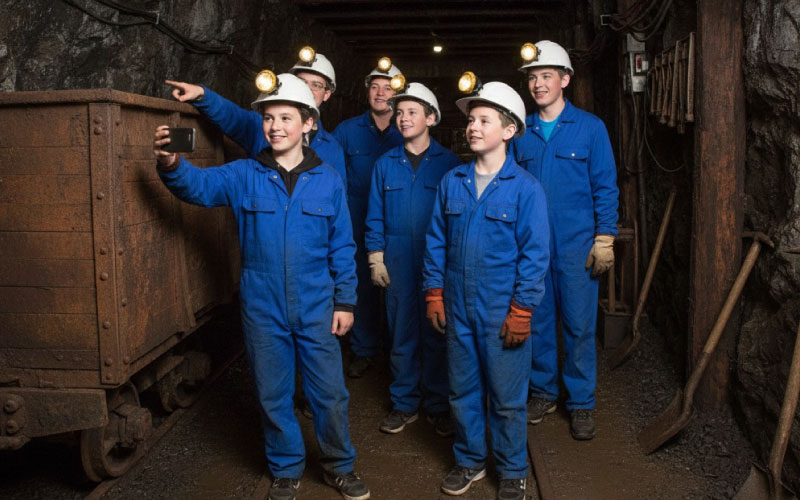 Students wearing helmets exploring underground at Big Pit National Coal Museum