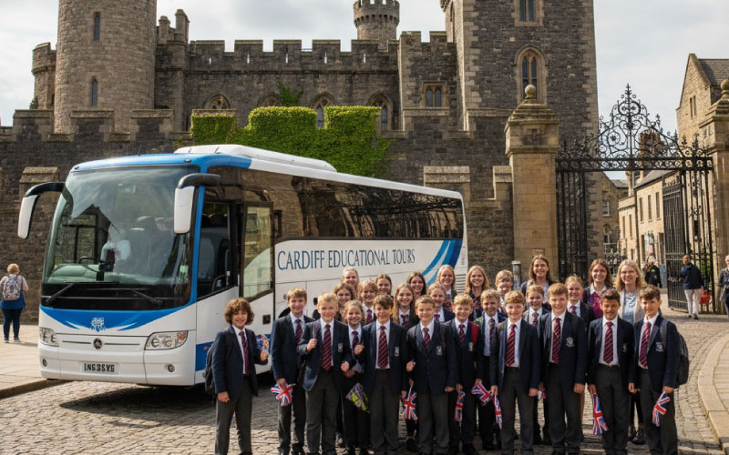 School coach parked outside Cardiff Castle with students preparing to enter